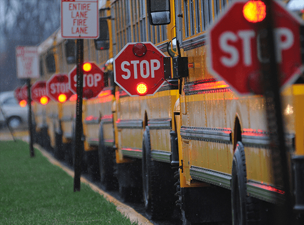 School busses flash STOP