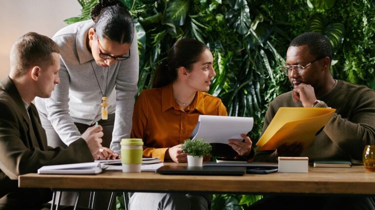 A group of professionals are sitting together to discuss ICHRA