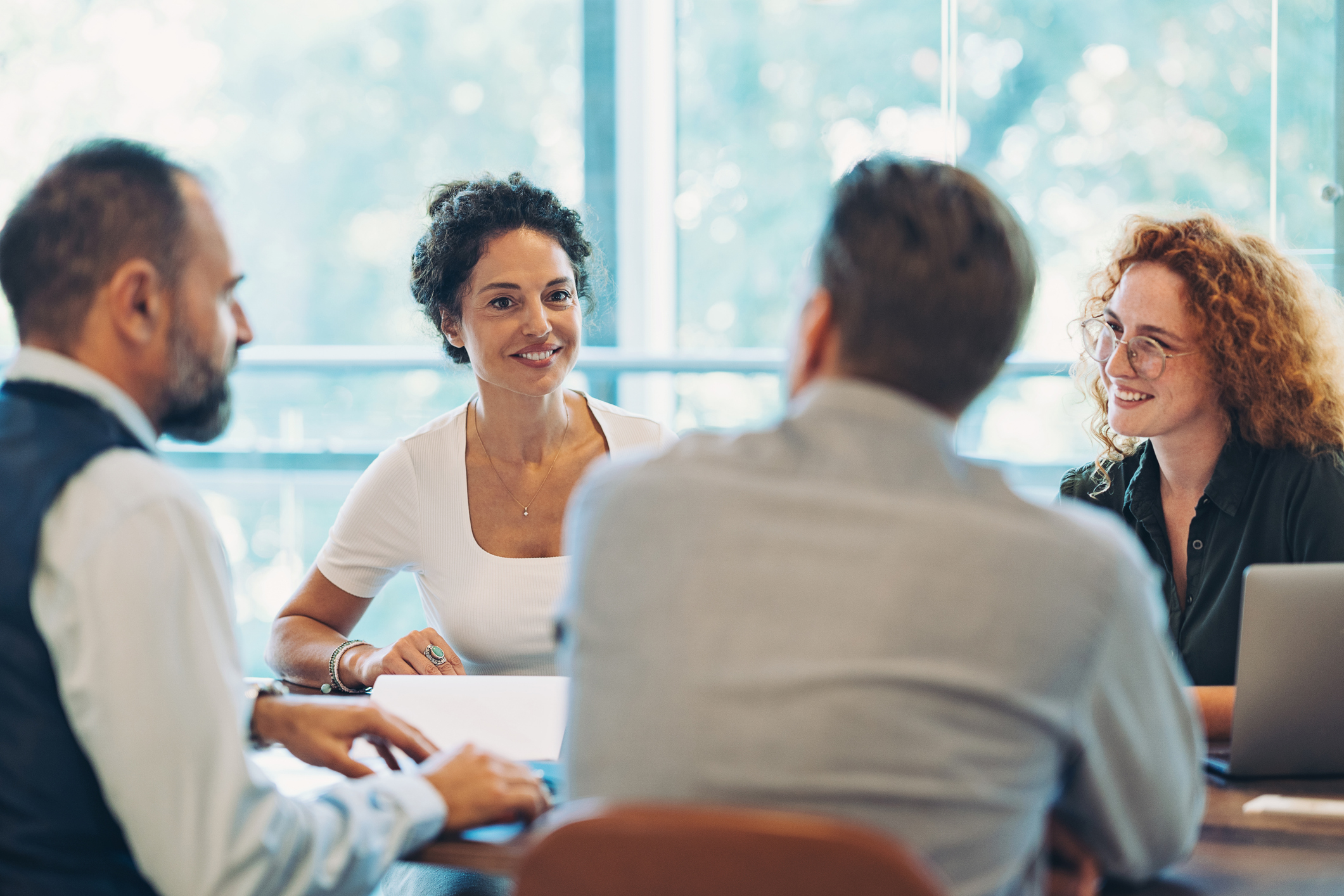 Business persons sitting around a table and talking