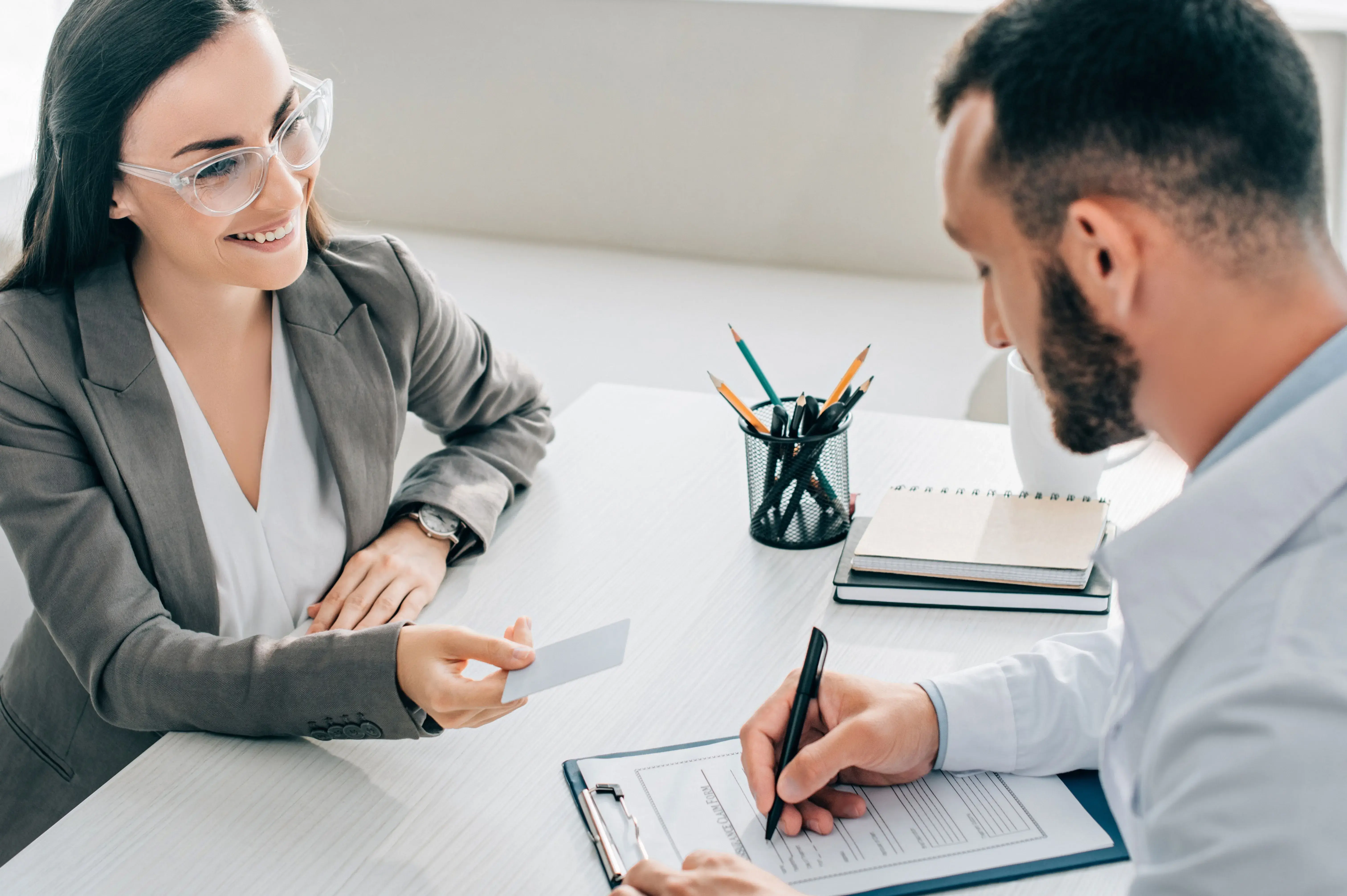 two individuals at a table working on documents